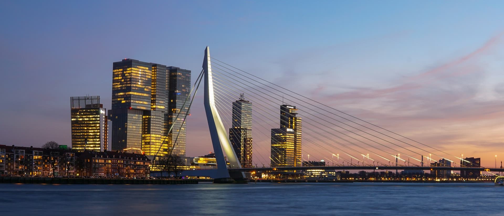 Skyline van Rotterdam met de Erasmusbrug tijdens blauw uur